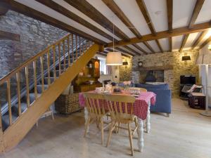 a dining room with a table and a staircase at Whitcombe Cottage in Honiton