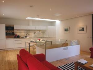 a large kitchen with a red couch and a table at The Gallery in Loddiswell