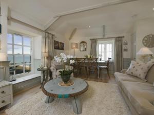 a living room with a couch and a table at Coach House Cottage in Strete