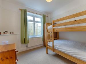 a bedroom with two bunk beds and a window at The Porthole in Newton Ferrers