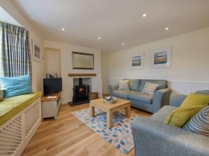 uma sala de estar com dois sofás e uma televisão em Junket Cottage em Newton Ferrers