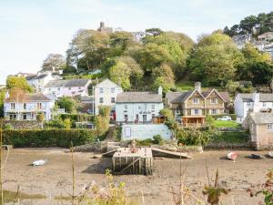 een groep huizen op een heuvel met een strand bij Junket Cottage in Newton Ferrers