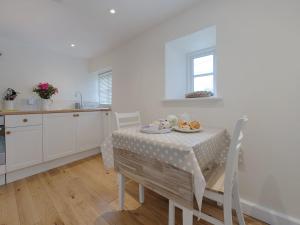a kitchen with a table with a tablecloth on it at Torrings Barn in Kingsbridge