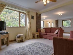 a living room with a couch and a tv at Galanda Treetops in Newton Ferrers