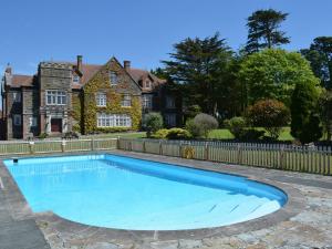 a swimming pool in front of a house at Alston Hall in Holbeton