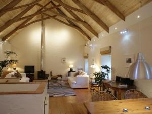 a large living room with a wooden ceiling with beams at The Barn in Aveton Gifford