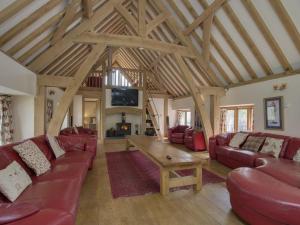 uma sala de estar com mobiliário vermelho e um tecto de madeira em The Roundhouse em Halwell