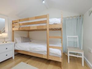 a bedroom with two bunk beds and a desk at Torrings Barn in Kingsbridge