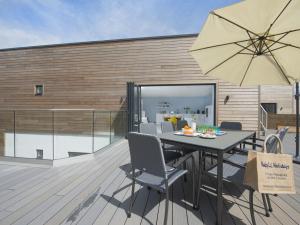 a patio with a table and chairs and an umbrella at 5 Beachdown in Bigbury