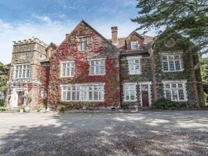 a large brick house with ivy growing on it at Alston Hall in Holbeton