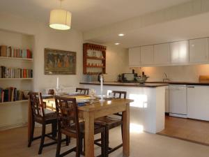 una cocina con mesa de madera y sillas. en Tom en Bodmin