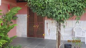 una casa con una puerta de madera y un árbol en Chalés e suite Ilhabela, en Ilhabela