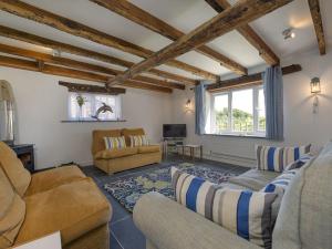 a living room with two couches and a tv at Salty Cottage in Morwenstow