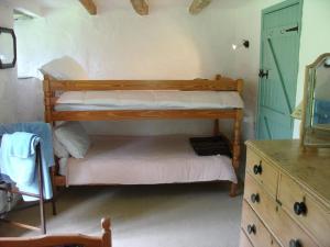 a bedroom with a bunk bed and a dresser with a mirror at Harry in Bodmin