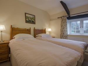 two twin beds in a bedroom with a window at Tumrose Cottage in Blisland