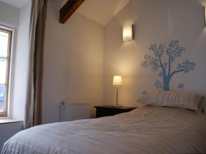a bedroom with a bed with a tree mural on the wall at The Workshop in Bude