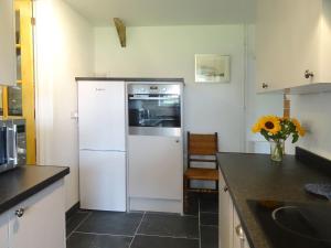a kitchen with a white refrigerator and a counter at Salty Cottage in Morwenstow