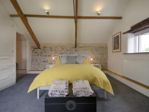a bedroom with a bed with a yellow bedspread at Salty Cottage in Morwenstow