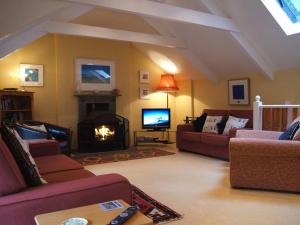 a living room with a couch and a fireplace at Grooms Cottage in Saint Minver