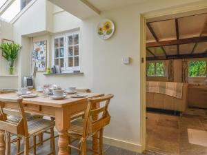 uma sala de jantar com uma mesa de madeira e cadeiras em 1 Gabberwell Cottages em Kingston