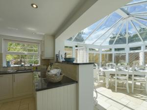 een keuken en eetkamer met een groot glazen raam bij Mays Cottage in Saint Issey