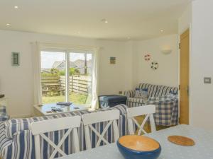 a living room with a table and chairs and a window at Upper Deck in Bude
