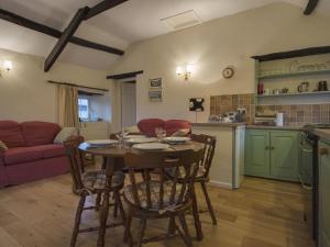 a kitchen and living room with a table and chairs at Tumrose Cottage in Blisland