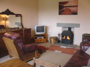 a living room with a fireplace and a television at Tresungers Cottage in Port Isaac