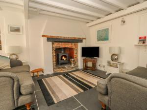 a living room with two couches and a fireplace at Cousham Cottage in Cawsand