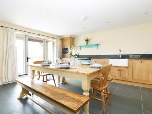 a large kitchen with a wooden table and chairs at Dozmary Pool Barn in Temple