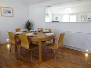 a dining room with a wooden table and chairs at The Workshop in Bude