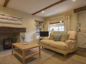 a living room with a couch and a fireplace at Cherry Tree Cottage in Noss Mayo