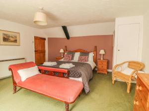 カウサンドにあるCousham Cottageのベッドルーム1室(ベッド1台、赤い椅子付)
