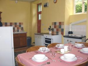 eine Küche mit einem Tisch mit Tellern und Weingläsern in der Unterkunft Tresungers Cottage in Port Isaac