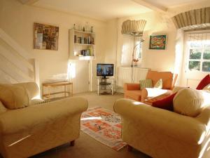 a living room with two couches and a tv at Dick Cottage in Bodmin