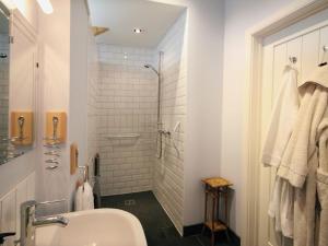 a white bathroom with a shower and a sink at Mugwell Barn in Callington