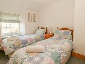 ボスキャッスルにあるFuchsia Cottageのベッドルーム1室(ベッド2台、窓付)