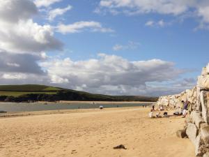 a group of people sitting on a sandy beach at Tresungers Cottage in Port Isaac +11 photos