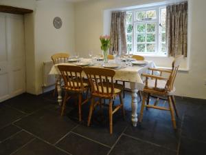 a dining room with a table with chairs and a window at Kingbarth in Lerryn