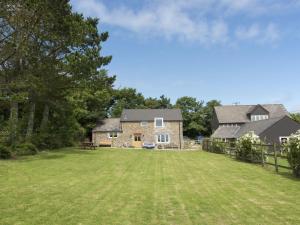 a large yard in front of a stone house at Salty Cottage in Morwenstow