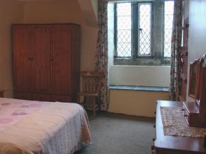 a bedroom with a bed and a window and a chair at Tresungers Cottage in Port Isaac