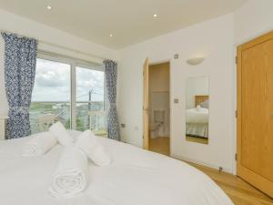 a bedroom with a white bed and a window at Upper Deck in Bude