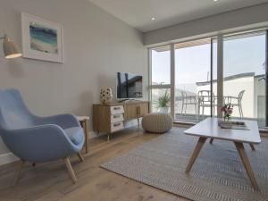 a living room with a blue chair and a table at Rosen in Crantock