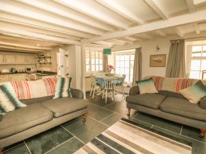 a living room with two couches and a table at Cousham Cottage in Cawsand