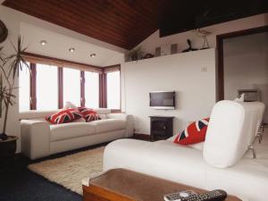 a living room with two white couches and a television at Seagulls Nest in Cawsand