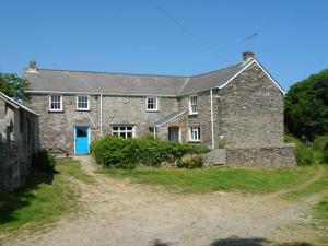 an old stone house with a blue door at Polcreek Farmhouse in Veryan