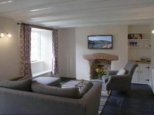a living room with a couch and chairs and a fireplace at Kingbarth in Lerryn
