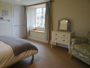 a bedroom with a bed and a mirror and a chair at Kingbarth in Lerryn
