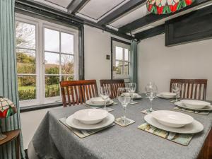 a dining room with a table with plates and wine glasses at Boundys House in St Ives
