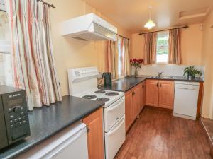 a kitchen with white appliances and wooden floors at Steepe's Place in Glenosheen